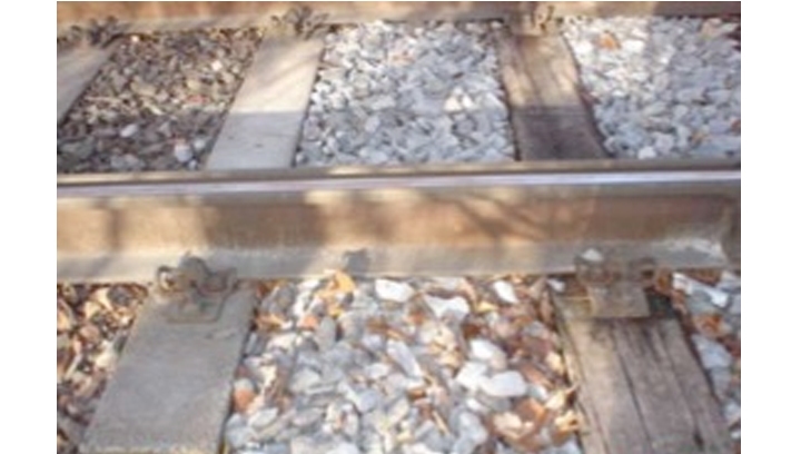 Composite rail sleepers in place next to worn wood rail sleeper